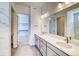 Bright bathroom featuring a double vanity with elegant countertops and a large mirror at 22097 E Rockinghorse Pkwy, Aurora, CO 80016