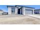 Modern home exterior with stone accents, a gray garage door, and a xeriscaped front yard at 22097 E Rockinghorse Pkwy, Aurora, CO 80016