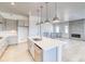 Bright kitchen with stainless steel appliances, white island and gas range, open to the living area at 22097 E Rockinghorse Pkwy, Aurora, CO 80016