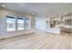 Open living space with light wood floors leads to modern kitchen with island and pendant lighting at 22097 E Rockinghorse Pkwy, Aurora, CO 80016