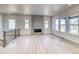 Bright living room with modern fireplace, light wood floors, and large windows providing ample natural light at 22097 E Rockinghorse Pkwy, Aurora, CO 80016