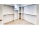 Spacious walk-in closet with multiple shelving units and neutral carpeting providing ample storage at 22097 E Rockinghorse Pkwy, Aurora, CO 80016