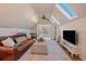 Living space featuring skylights, a ceiling fan, leather couch, and TV at 3613 Julian St, Denver, CO 80211