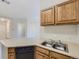 Kitchen with a double sink and wood cabinets overlooking a doorway to another room at 19019 E Warren Dr # H206, Aurora, CO 80013