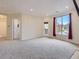 Bright living room featuring plush carpet, a balcony, and plenty of natural light through a large window at 19019 E Warren Dr # H206, Aurora, CO 80013