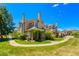 Beautiful townhome exterior with lush green lawn, mature landscaping, and charming brick accents on a sunny day at 4760 S Wadsworth Blvd # 302, Littleton, CO 80123