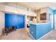 Cozy living room with blue accent wall, bar seating, and open access to the kitchen at 4760 S Wadsworth Blvd # 302, Littleton, CO 80123