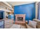 Open floor plan view of the living room with brick fireplace and a blue accent wall at 4760 S Wadsworth Blvd # 302, Littleton, CO 80123