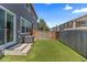 Backyard with artificial grass, wooden fence, and a patio area at 11062 Gaylord St, Northglenn, CO 80233
