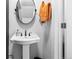 Bathroom featuring pedestal sink, oval mirror, with orange towels hanging nearby at 11062 Gaylord St, Northglenn, CO 80233