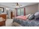 Bedroom featuring plush carpet, a ceiling fan, windows with blinds, and access to the bathroom at 11062 Gaylord St, Northglenn, CO 80233