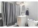 Clean bathroom with shower/tub combo and gray vanity at 2612 Meadowbrook Dr, Denver, CO 80221