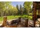 Serene backyard featuring a fire pit, wooden bench, and a lush green surrounding, ideal for relaxation at 1194 Camp Eden Rd, Golden, CO 80403
