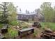 Spacious backyard with fire pit, bench, and wooded view at 1194 Camp Eden Rd, Golden, CO 80403