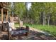 Backyard featuring firepit, wooden benches, stone patio and grassy space at 1194 Camp Eden Rd, Golden, CO 80403