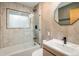 Modern bathroom with tiled shower, tub, and geometric-patterned accent wall at 1194 Camp Eden Rd, Golden, CO 80403