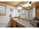 Stylish bathroom featuring a stone countertop, wood cabinets, a large mirror, and decorative glass block windows at 1194 Camp Eden Rd, Golden, CO 80403