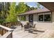Outdoor dining area on a wood deck with views of surrounding lush green trees at 1194 Camp Eden Rd, Golden, CO 80403
