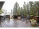 Outdoor deck with seating, potted plants, and a grill, perfect for enjoying the peaceful wooded setting at 1194 Camp Eden Rd, Golden, CO 80403