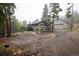 Charming home features a spacious driveway, two-car garage, and a wraparound deck, nestled among pine trees at 1194 Camp Eden Rd, Golden, CO 80403