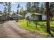 Exterior view showcasing a home and garage with a driveway, surrounded by lush greenery and trees at 1194 Camp Eden Rd, Golden, CO 80403