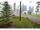 Garage with a large door and a fenced meadow in a serene wooded setting at 1194 Camp Eden Rd, Golden, CO 80403