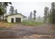 Garage with a large door and a fenced meadow in a serene wooded setting at 1194 Camp Eden Rd, Golden, CO 80403