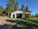 Exterior of a garage with a large door and covered area, surrounded by a well-kept lawn at 1194 Camp Eden Rd, Golden, CO 80403