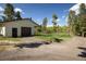 Exterior view of the garage with a garage door and covered area, near a gravel driveway and grassy area at 1194 Camp Eden Rd, Golden, CO 80403