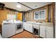 Bright laundry room with modern washer and dryer, sink, and plenty of storage at 1194 Camp Eden Rd, Golden, CO 80403