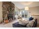 Cozy living room features a striking stone fireplace and access to the outdoor deck at 1194 Camp Eden Rd, Golden, CO 80403