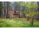 Exterior view of a rustic log cabin surrounded by trees and greenery at 1194 Camp Eden Rd, Golden, CO 80403