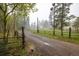 Private property entrance with a rail fence and a gravel driveway surrounded by trees at 1194 Camp Eden Rd, Golden, CO 80403