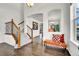Bright entryway features hardwood floors, staircase with iron spindles, and an orange accent bench at 11845 Mobile St, Commerce City, CO 80022