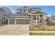 Beautiful two-story home boasts a three-car garage, gray siding, and a manicured lawn at 11845 Mobile St, Commerce City, CO 80022