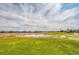 Expansive golf course view featuring a pond, manicured green, and distant residential area at 11845 Mobile St, Commerce City, CO 80022