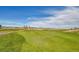 Scenic view of a golf course with vibrant green grass, water features, and clear skies at 11845 Mobile St, Commerce City, CO 80022