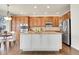 Bright kitchen with wood cabinets, stainless steel appliances, center island and adjacent dining area at 11845 Mobile St, Commerce City, CO 80022