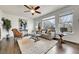 Bright living room features a fan, rug, couch, painting, and a large window for natural light at 11845 Mobile St, Commerce City, CO 80022