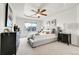 Primary bedroom suite with tray ceiling, fan, and sitting area at 11845 Mobile St, Commerce City, CO 80022