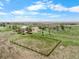 Aerial view of ranch home surrounded by fenced yards and a horse paddock at 32501 E 137Th Way, Brighton, CO 80603
