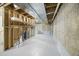Unfinished basement area with exposed ceiling, concrete walls, and a white painted floor at 32501 E 137Th Way, Brighton, CO 80603