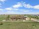 Sprawling ranch-style home with white fence on a lush, open lot and a detached garage on a sunny day at 32501 E 137Th Way, Brighton, CO 80603