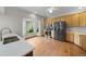Bright kitchen featuring stainless steel appliances, light wood cabinets, hardwood floors, and a bay window at 32501 E 137Th Way, Brighton, CO 80603