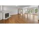 Light-filled living room featuring hardwood floors, a white fireplace, ceiling fan, and doors to the backyard at 32501 E 137Th Way, Brighton, CO 80603