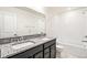 Bathroom features double sinks with granite counters, tub, and modern fixtures at 9264 Biscay St, Commerce City, CO 80022