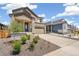View of home exterior showing landscaping with stone mulch, lawn, and a concrete driveway at 9264 Biscay St, Commerce City, CO 80022