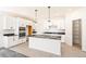 Modern kitchen with white cabinets, marble countertops, and stainless steel appliances, plus island at 9264 Biscay St, Commerce City, CO 80022