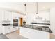 Contemporary kitchen featuring white cabinetry, black countertops, a central island, and stainless steel appliances at 9264 Biscay St, Commerce City, CO 80022