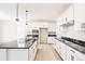 Modern kitchen featuring sleek white cabinetry, black countertops, and stainless steel appliances at 9264 Biscay St, Commerce City, CO 80022